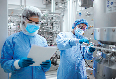 Wissenschaftler bei Bioreaktor (Foto)